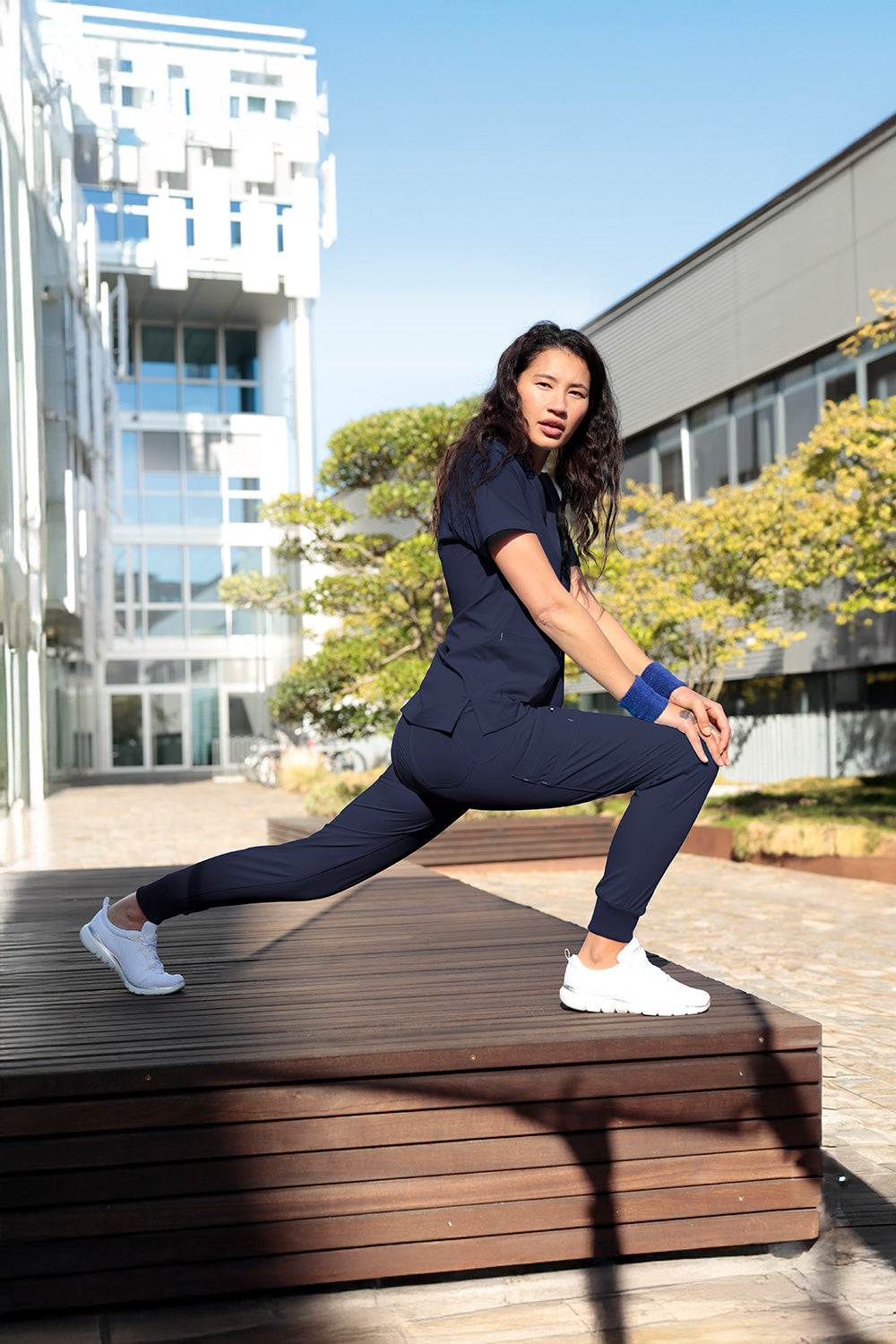 Damen-Model macht Ausfallschritt-Pose in navy farbener KAERE Jogpants Hose.