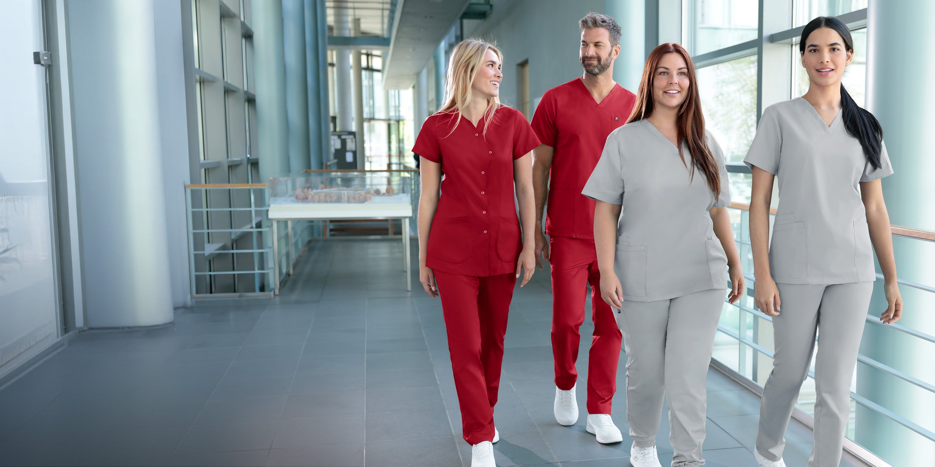 Teamaufnahme an der Praxis-Rezeption, 3 Damen- und 1 Herren-Model ausgestattet mit der GREEN Kollektion.